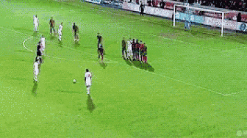 a soccer game is being played on a field with advertisements for vodafone and lan .