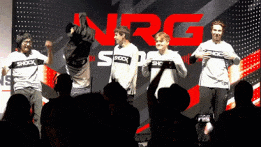 a group of people standing in front of a sign that says shock