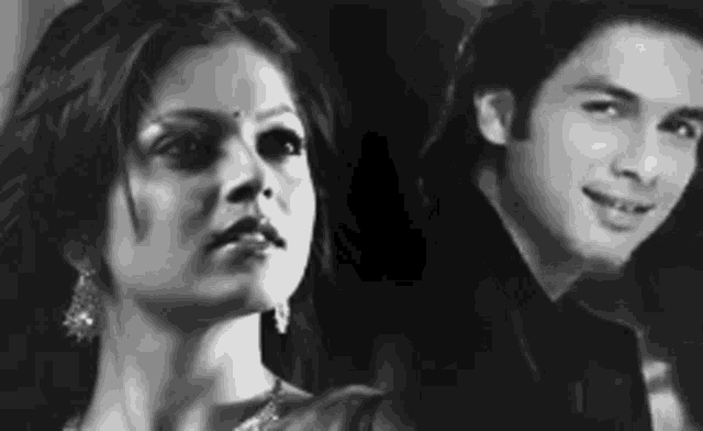 a man and a woman are standing next to each other and looking at the camera .