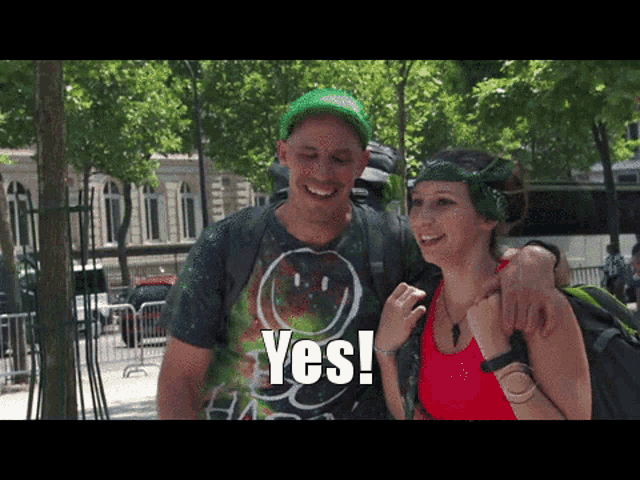 a man and woman are posing for a picture and the woman is wearing a yes shirt