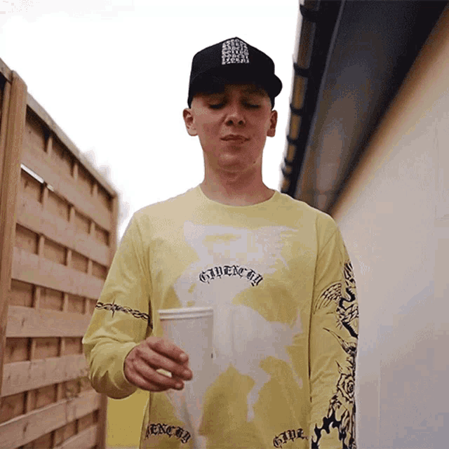 a man wearing a yellow shirt that says givenchy