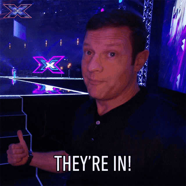 a man in a black shirt says they 're in in front of a stage