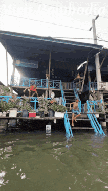 a man jumps into a body of water in front of a building