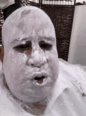 a man with a white mask on his face looks sad