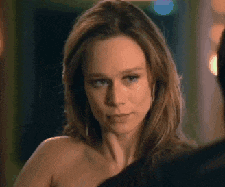 a woman without a shirt is looking at a man in a suit