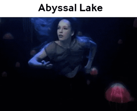 a woman is swimming underwater in an abyssal lake with jellyfish .