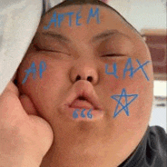a close up of a person 's face with blue writing on it and a star drawn on it .