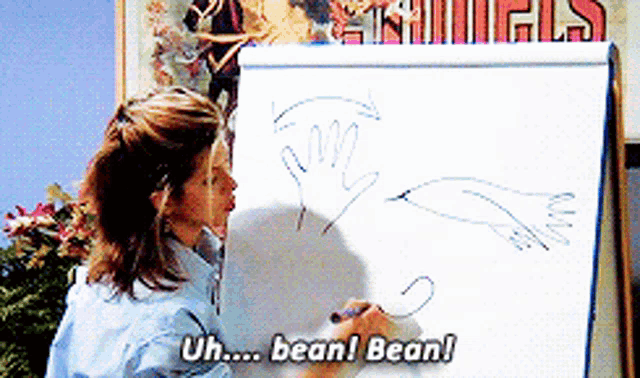 a woman drawing on a white board with the words uh bean bean