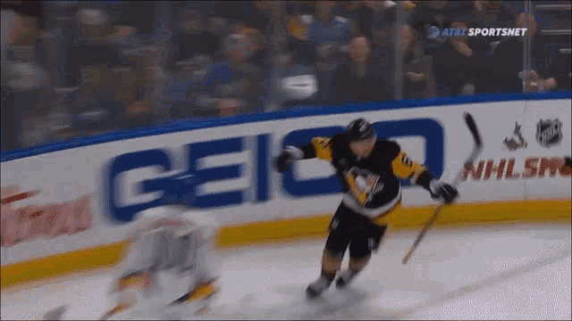 a hockey game is being played in front of an ad for geico