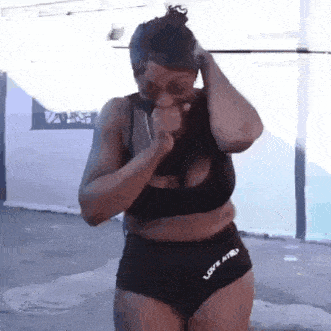a woman in a bikini is standing in front of a white wall .