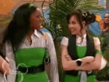 two women are standing next to each other with their arms crossed .