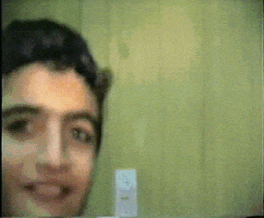 a close up of a man 's face with a remote in front of him