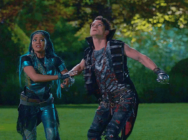 a man and a woman are standing on a grassy field