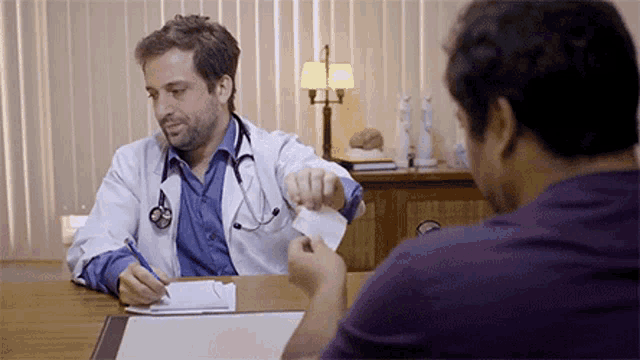 a doctor is giving a patient a piece of paper to sign