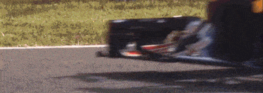 a man wearing a helmet is driving a race car on a track .