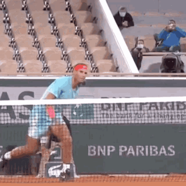a man is playing tennis in front of a bnp pariba sign