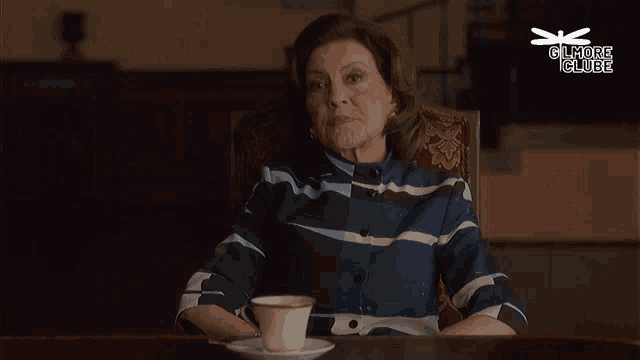 a woman sits at a table with a cup of coffee and a dragonfly above her that says gilmore glue
