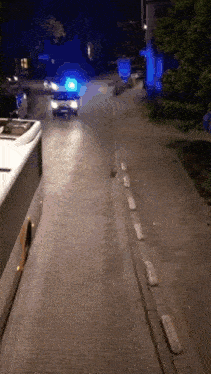 a police car is driving down a street with a blue light on