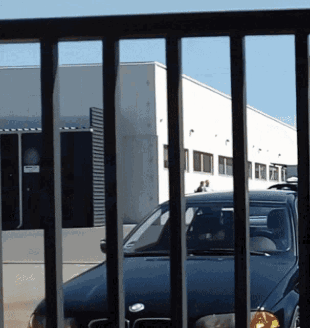 a black car is parked in front of a building that has a sign that says no parking