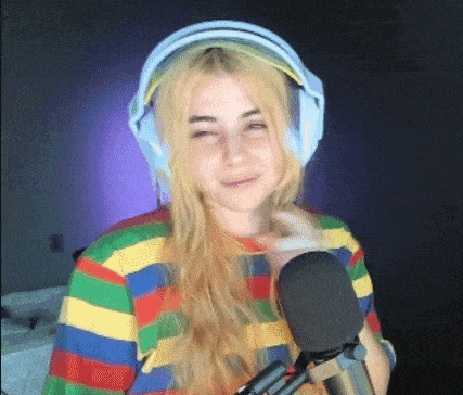 a young woman wearing headphones and a striped shirt is standing in front of a microphone .