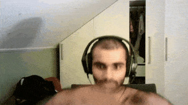 a man wearing headphones is sitting in front of a wardrobe