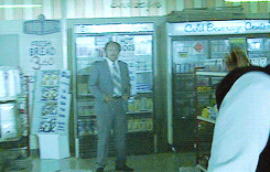 a man in a suit and tie stands in front of a cooler that says c & b bakery on it
