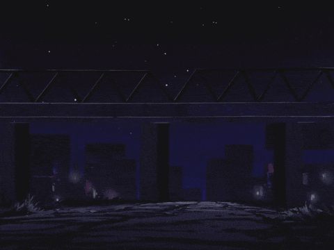 a bridge over a body of water at night with a city in the background and a few lights on