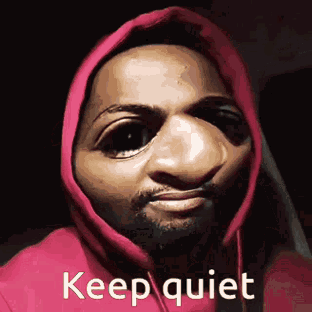 a man wearing a red hoodie with the words keep quiet written on it