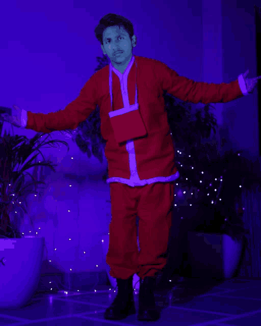 a man in a santa suit is standing in front of a blue light