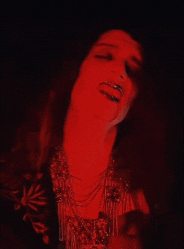 a close up of a woman 's face with a red background