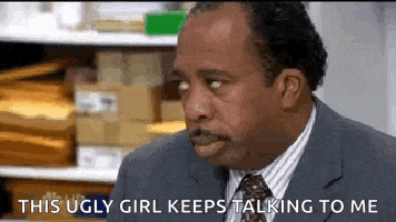 a man in a suit and tie is talking to a woman in a warehouse .