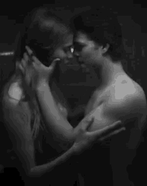 a man and a woman kissing in a black and white photo .