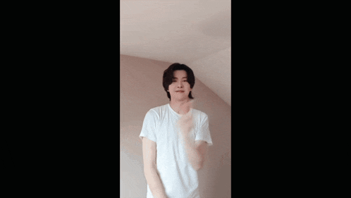 a man in a white shirt is giving the peace sign