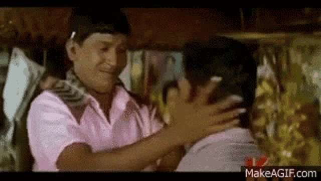 a couple of men are hugging each other in a room .