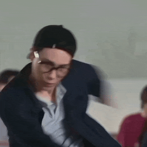 a group of young men are standing in a room and one of them is dancing .