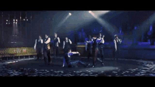 a group of people are dancing on a stage