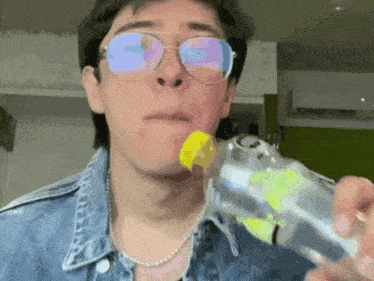 a man wearing glasses and a pearl necklace is holding a bottle in his hand