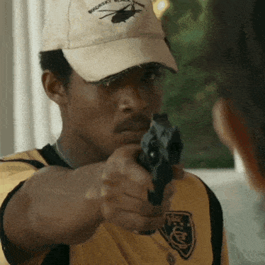a man wearing a hat that says smokey blackhawk is pointing a gun