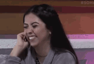 a woman is laughing and talking on a cell phone .