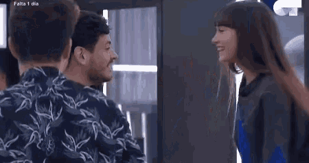 a man and a woman are standing next to each other in a room and smiling .