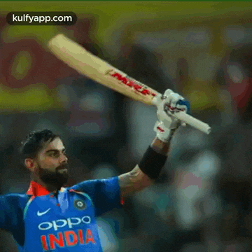 a man in an oppo india jersey is holding a bat in the air