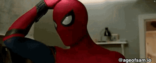 a close up of a person in a spiderman costume scratching his head .