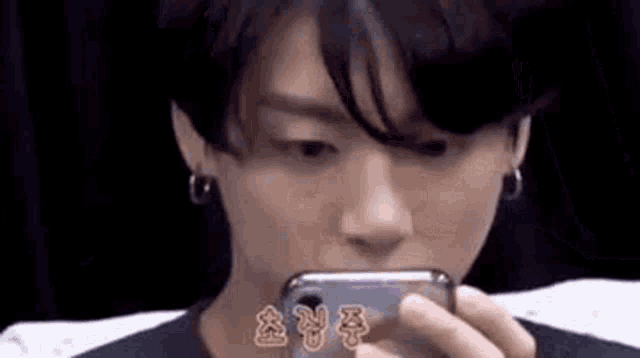 a young man is looking at a cell phone .