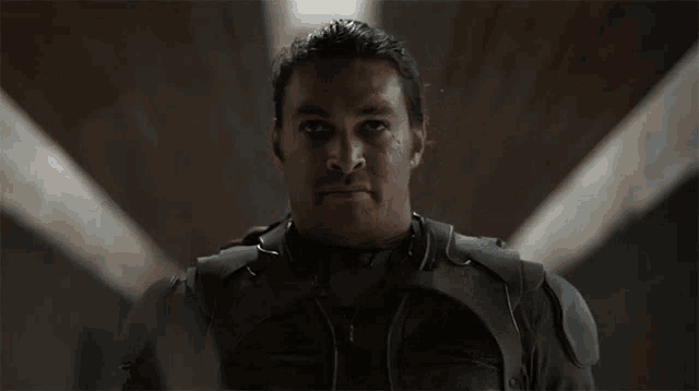 a man is holding a sword in front of his eye