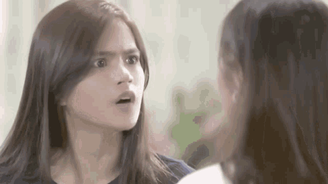 two women are talking to each other and one is making a funny face