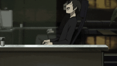a man is sitting at a desk in front of a window with the letter e on it