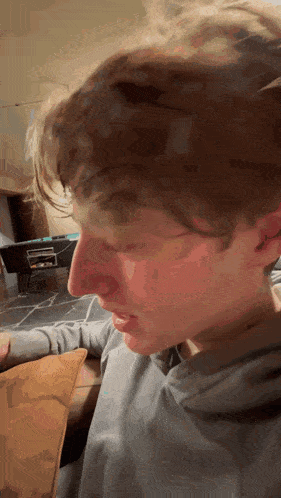 a close up of a person 's face with a gray shirt