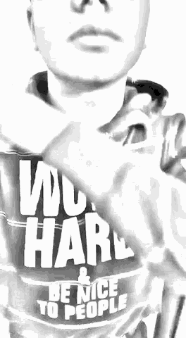 a black and white photo of a person wearing a sweatshirt that says work hard and be nice to people