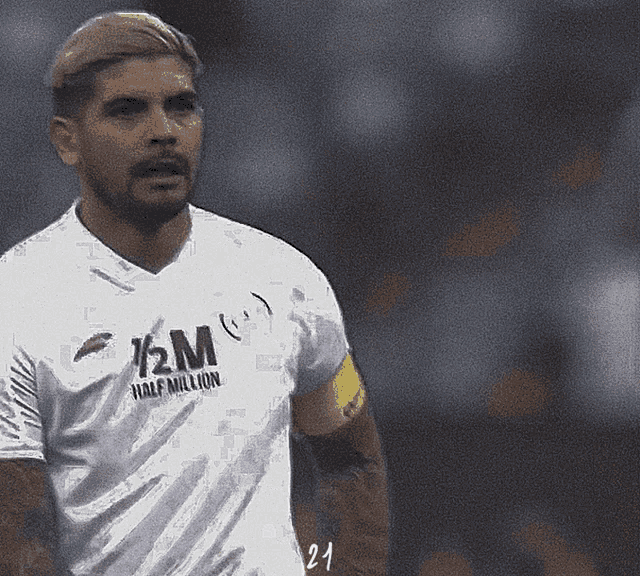 a soccer player wearing a white jersey with half million on it
