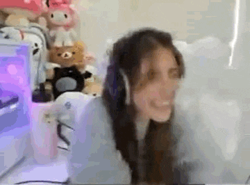 a woman wearing headphones is smiling while sitting in front of a computer .